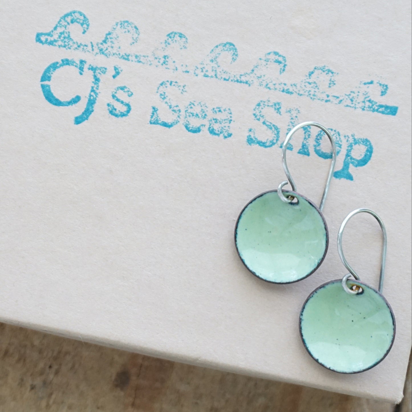 Pair of green earrings on a gift box