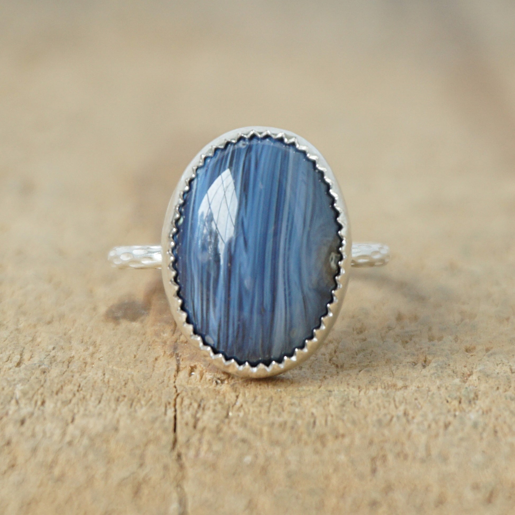 silver ring with a blue stone on a wooden background