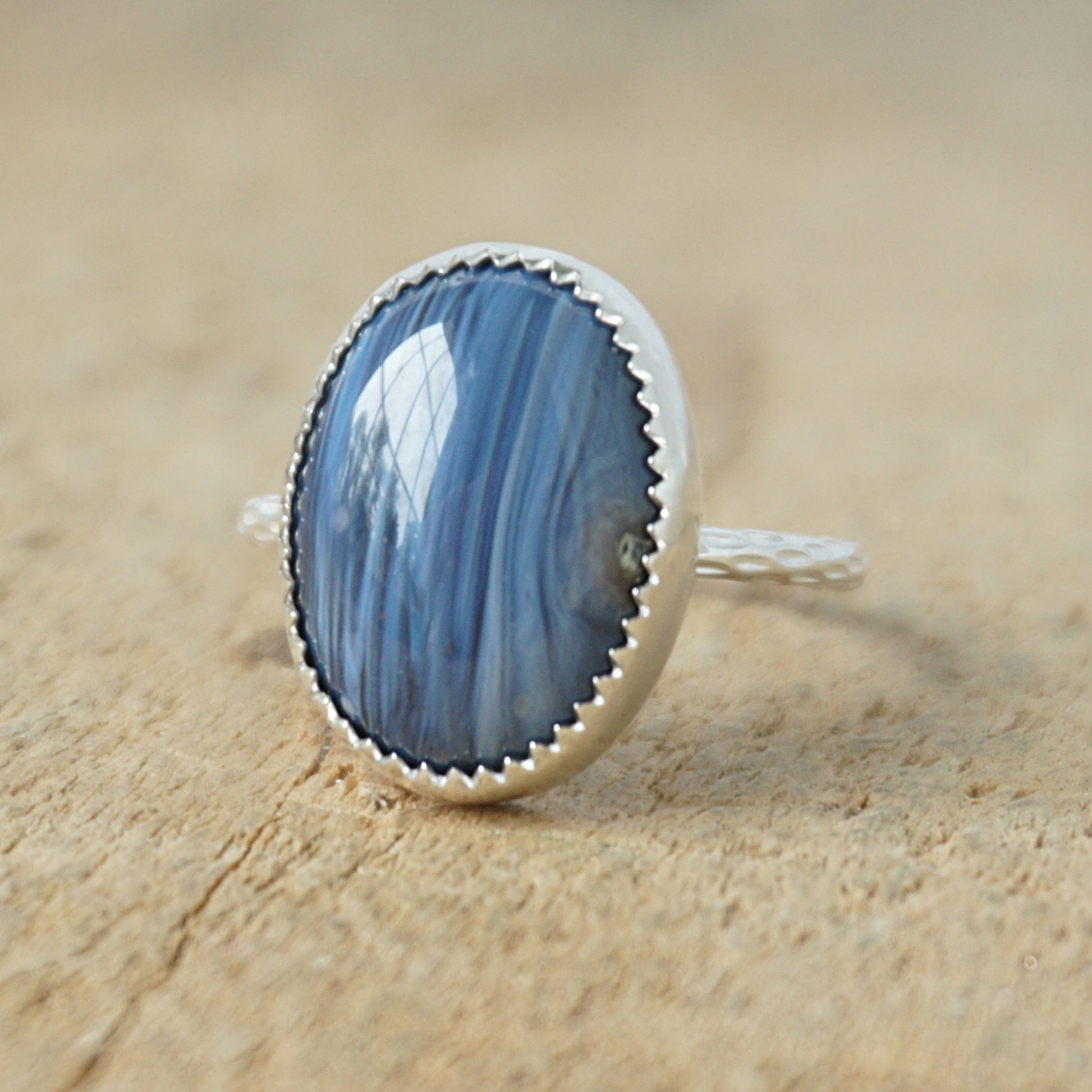 silver ring with a blue stone on a wooden background