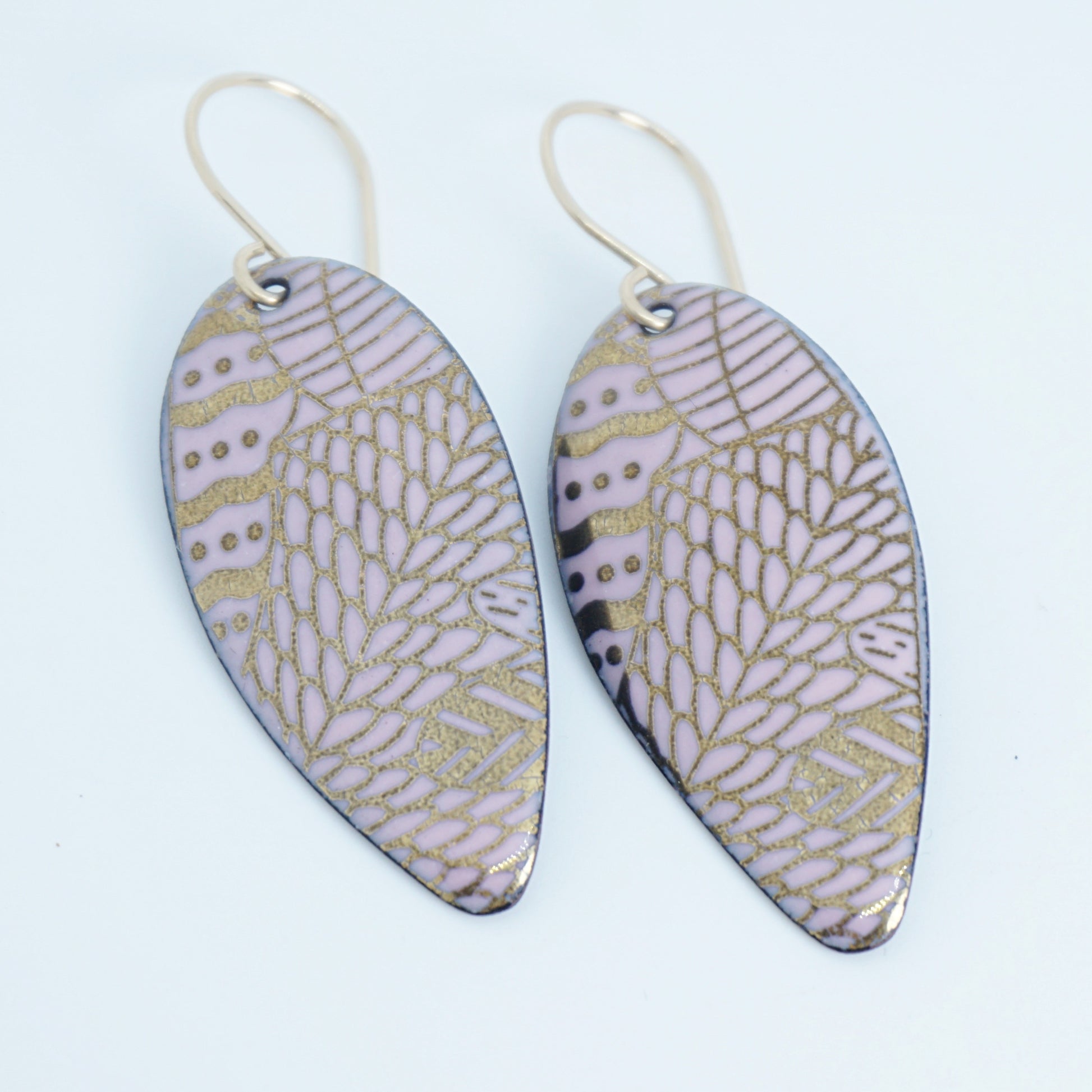 gold pattern on pink enamel teardrop shaped earrings, on a white background