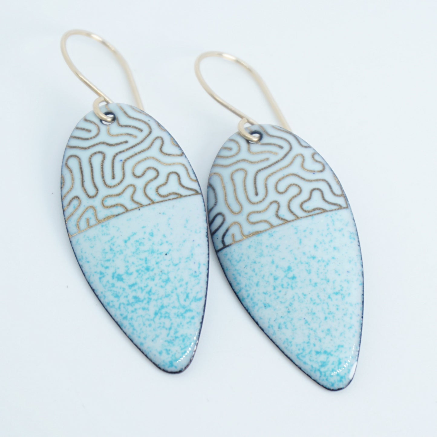 gold pattern on seafoam green enamel teardrop shaped earrings, on a white background