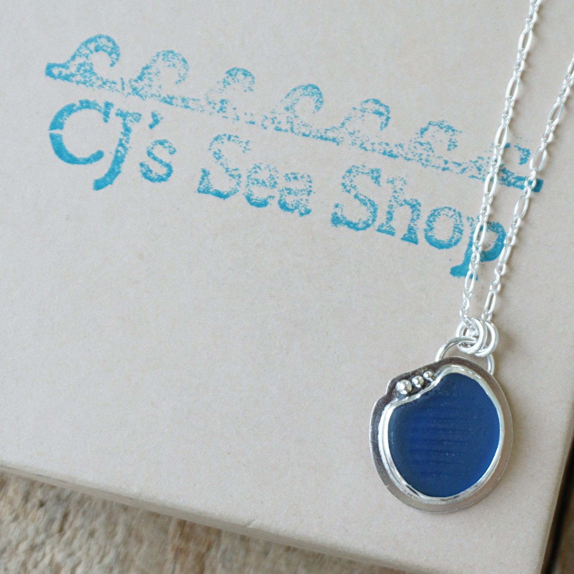 sterling silver and cobalt blue sea glass pendant, displayed on a gift box