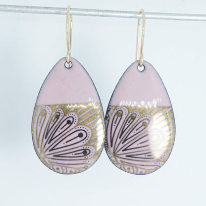 Teardrop shaped, pink enamel earrings with gold floral designs, against a white background