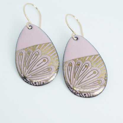 Teardrop shaped, pink enamel earrings with gold floral designs, against a white background