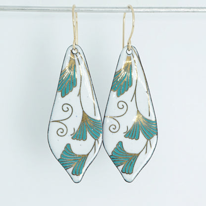 Teardrop shaped enamel earrings with green and gold leaves, against a white background