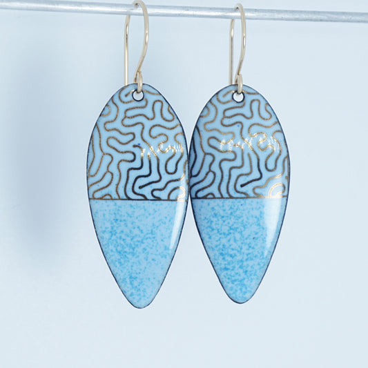 a pair of light blue enamel earrings with gold designs, against a white background