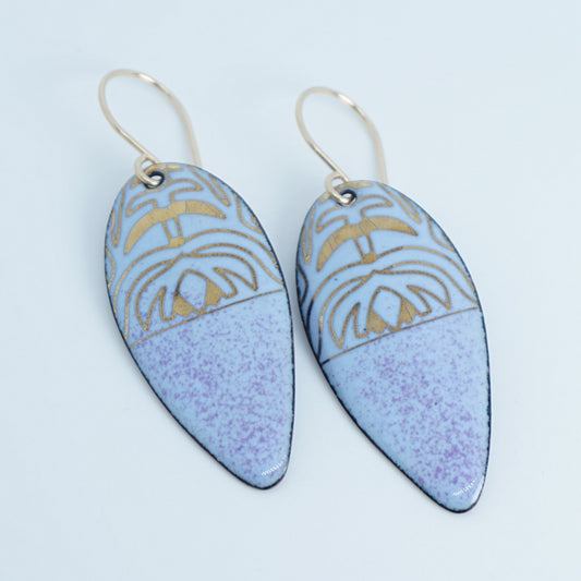 a pair of light purple enamel earrings with gold designs, against a white background