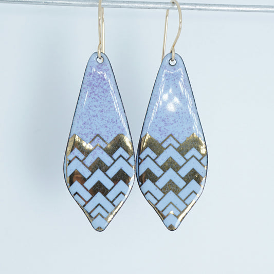 a pair of light purple enamel earrings with gold designs, against a white background