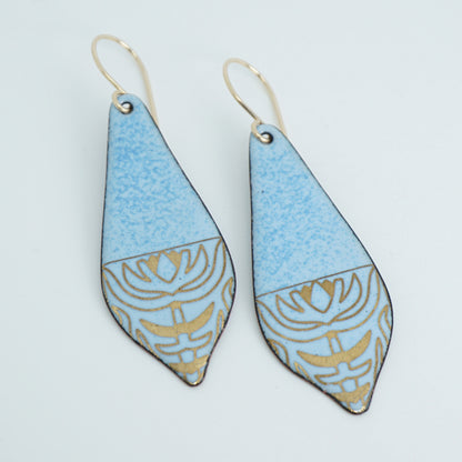 a pair of light blue enamel earrings with gold designs, against a white background