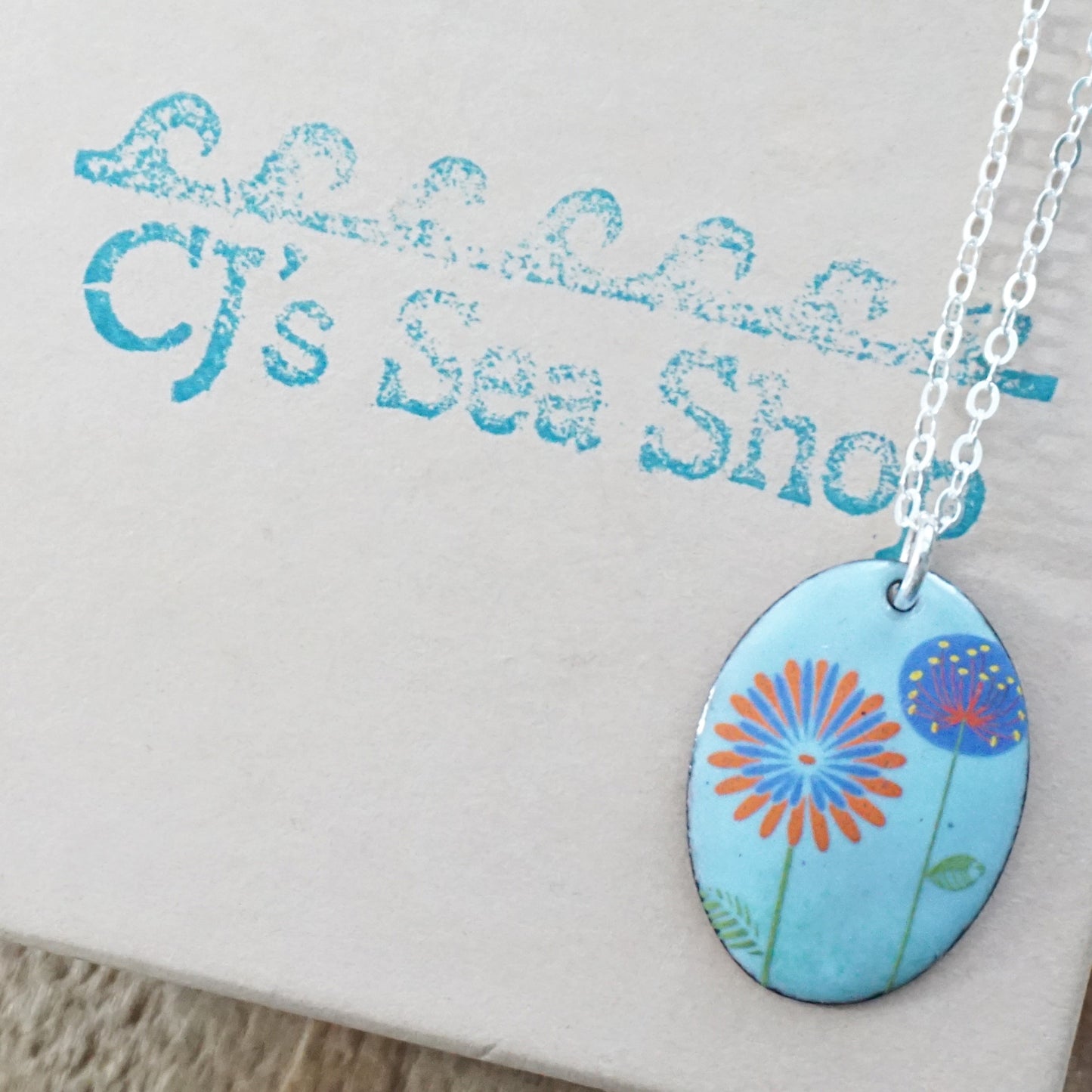 Red Daisy and Purple Dandelion on Light Blue Enamel Oval Pendant