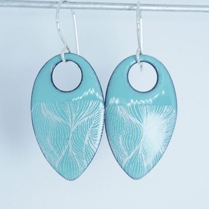 a pair of light green enamel teardrop shaped earrings with white feathery accents, against a white background