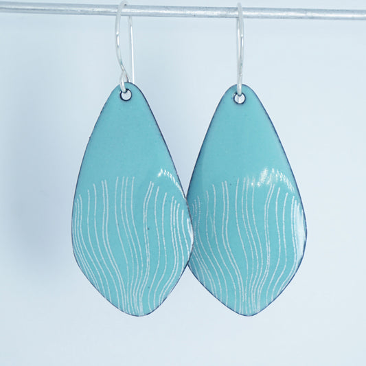 a pair of light green enamel teardrop shaped earrings with white wavy accents, against a white background