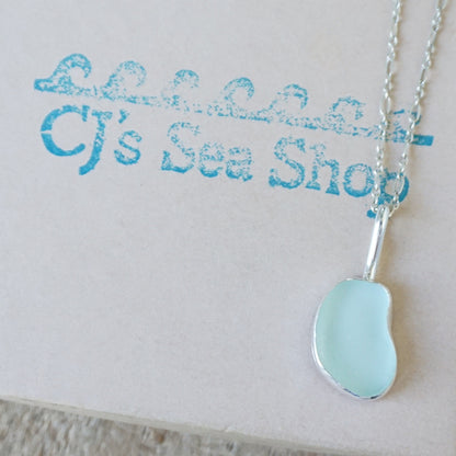 silver pendant with seafoam green sea glass, displayed on a gift box