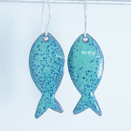 green and blue enamel fish shaped earrings, against a white background