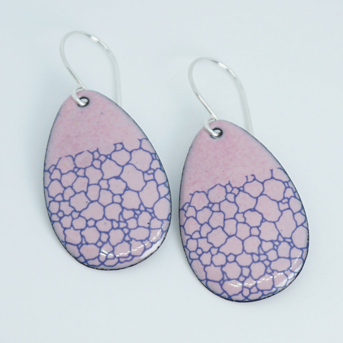 a pair of pink enamel teardrop shaped earrings with blue bubble accents, against a white background