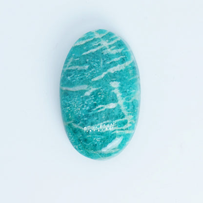 teal green stone with white veins on a light blue background