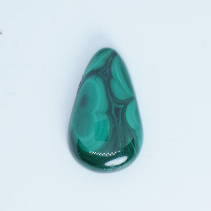 Teardrop-shaped malachite stone on a white background