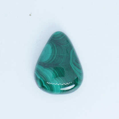 Teardrop-shaped green malachite stone on a white background