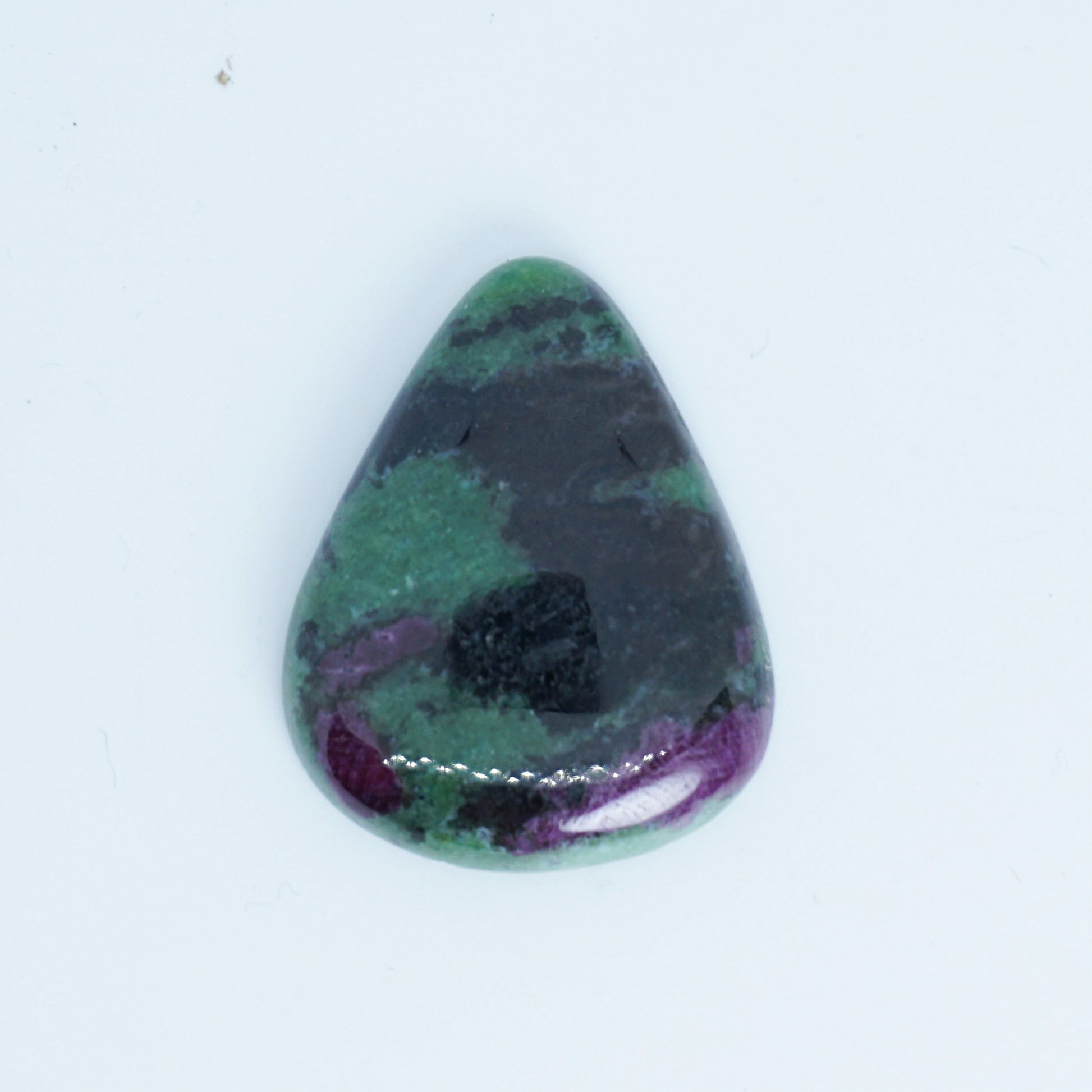Teardrop-shaped gemstone with green, purple, and black colors on a white background