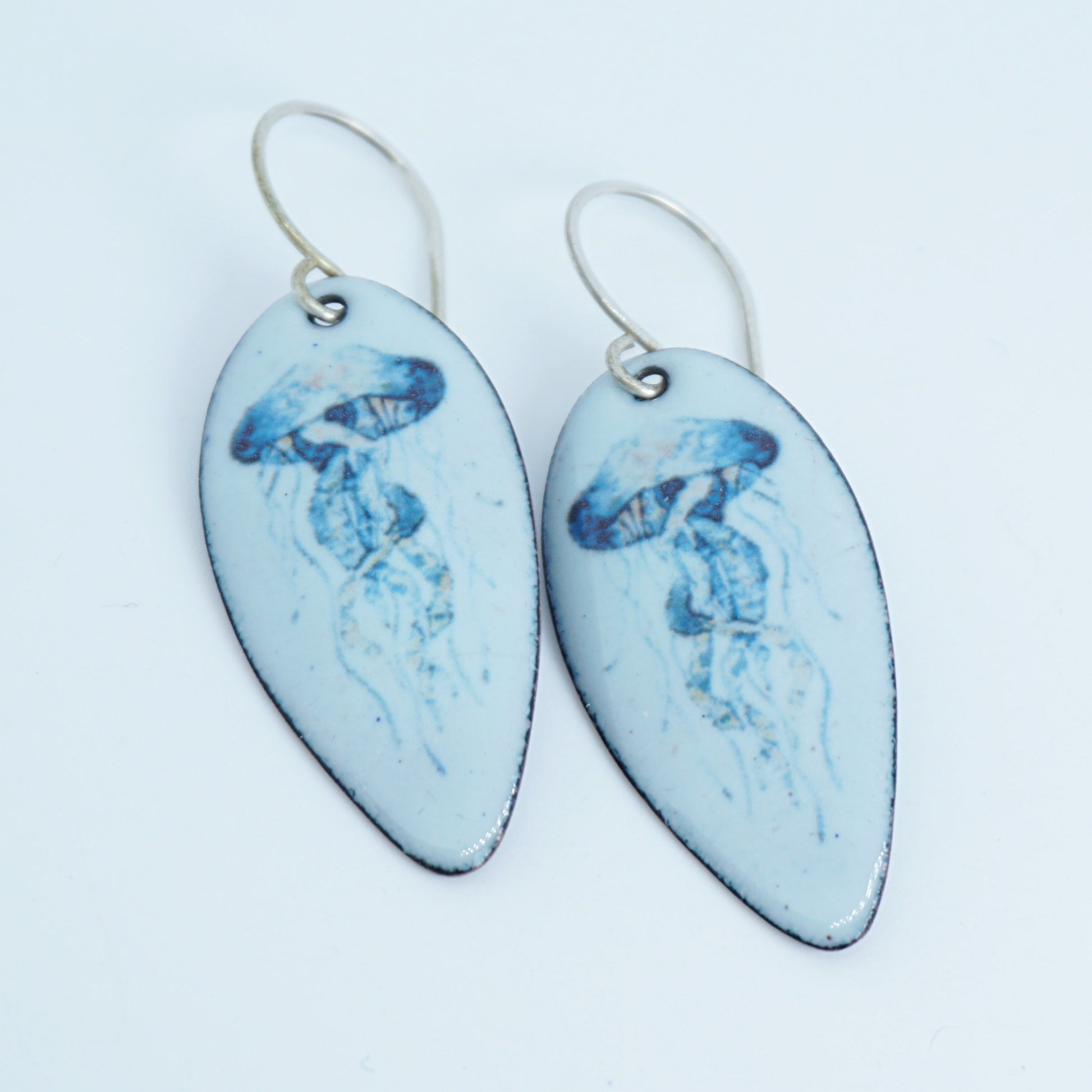 Pair of earrings with blue jellyfish design on white background