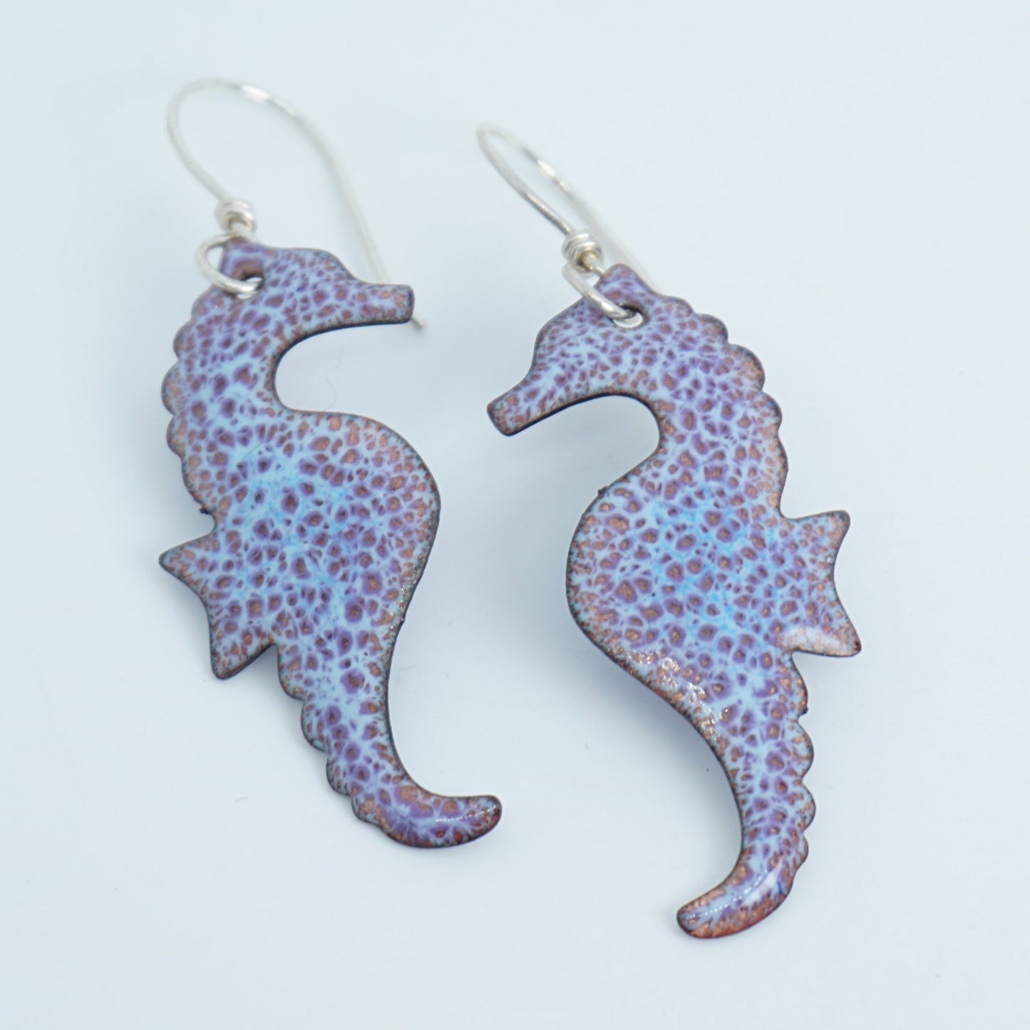 Pair of seahorse-shaped earrings on a white background