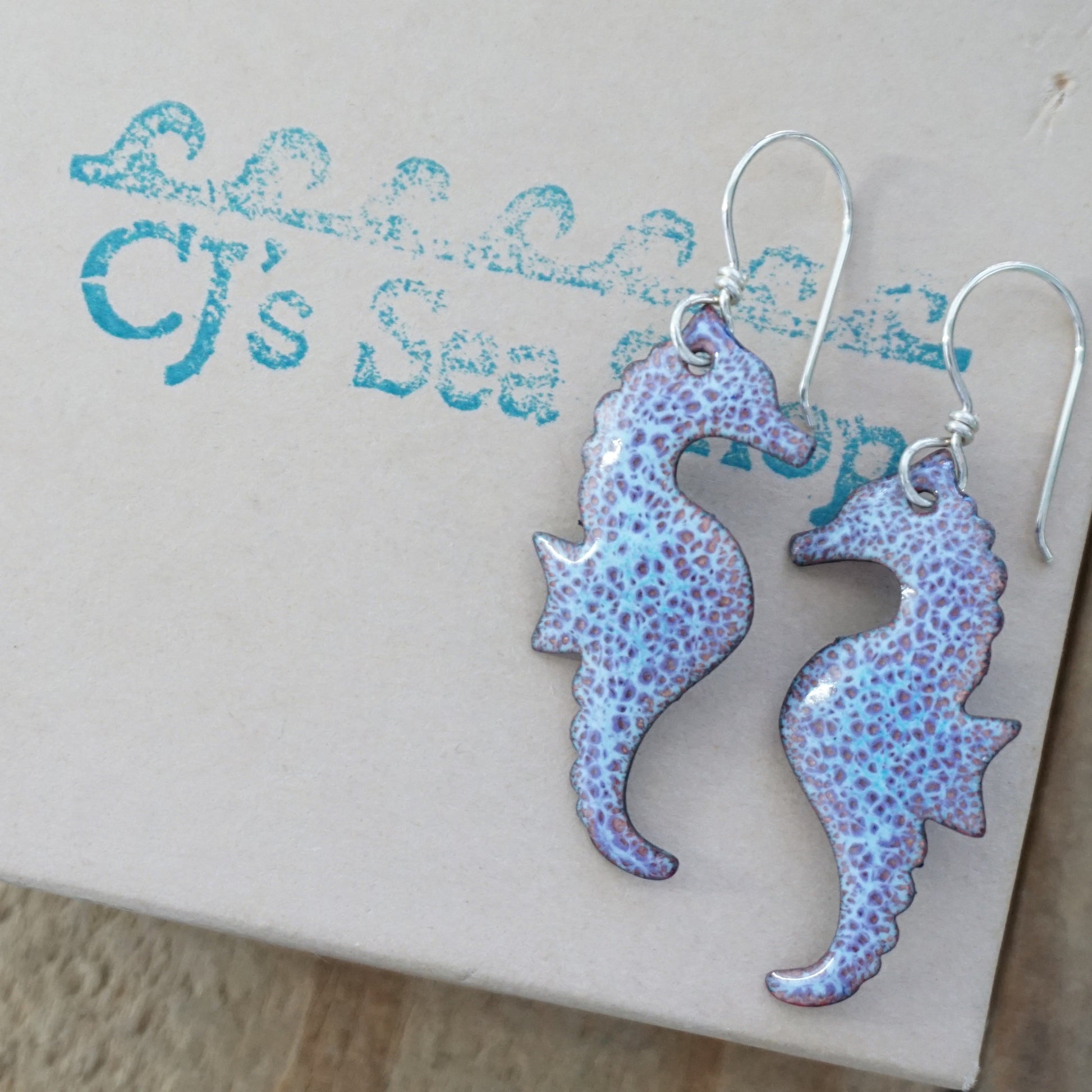 Seahorse-shaped earrings on a gift box