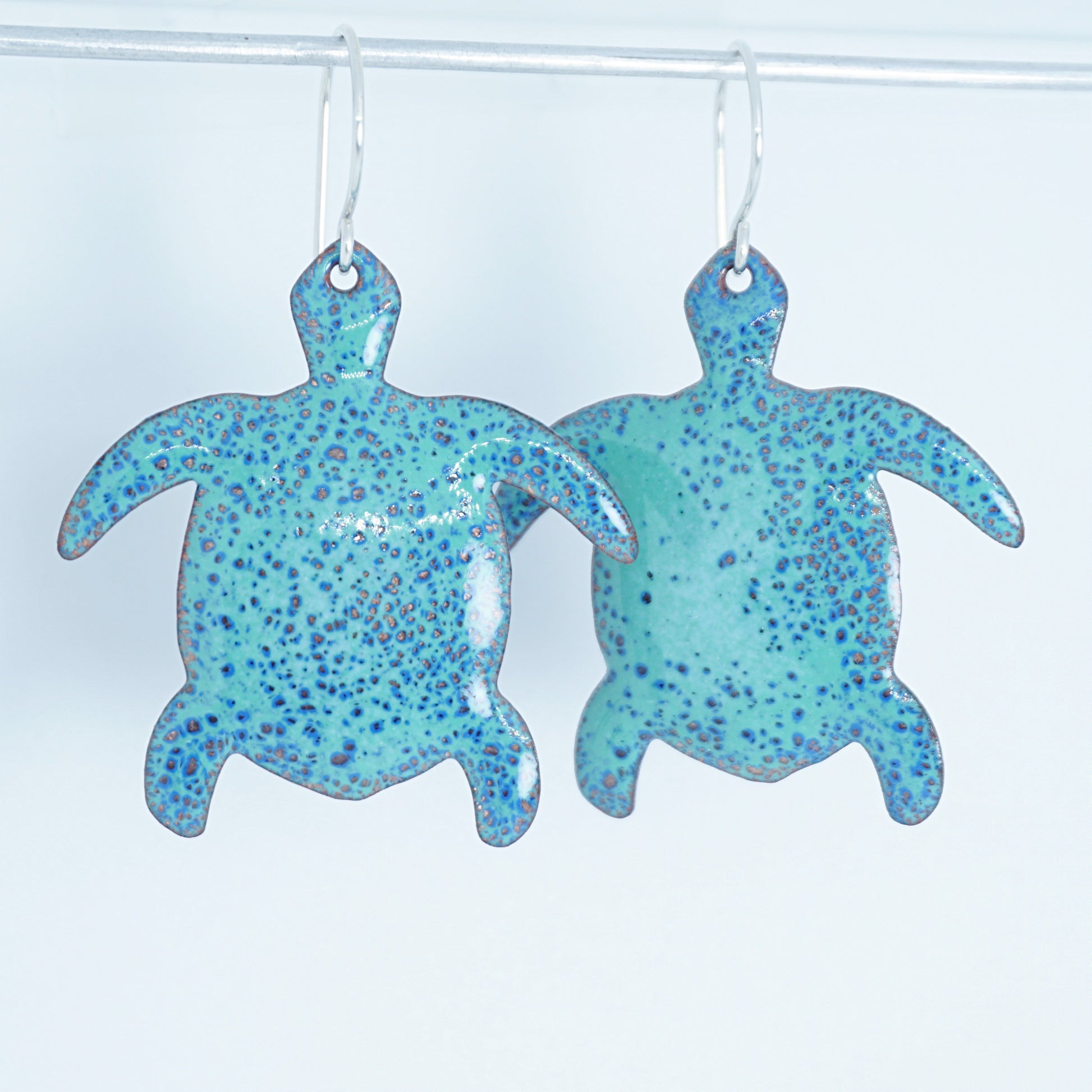 green turtle earrings on a white background