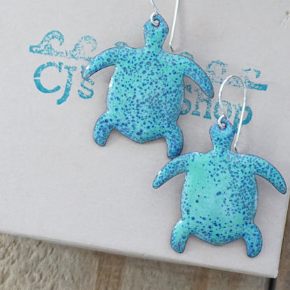 Green turtle-shaped earrings on a gift box