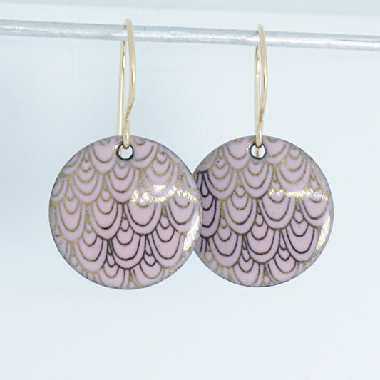 pink disc shaped earrings with gold accents on a white background