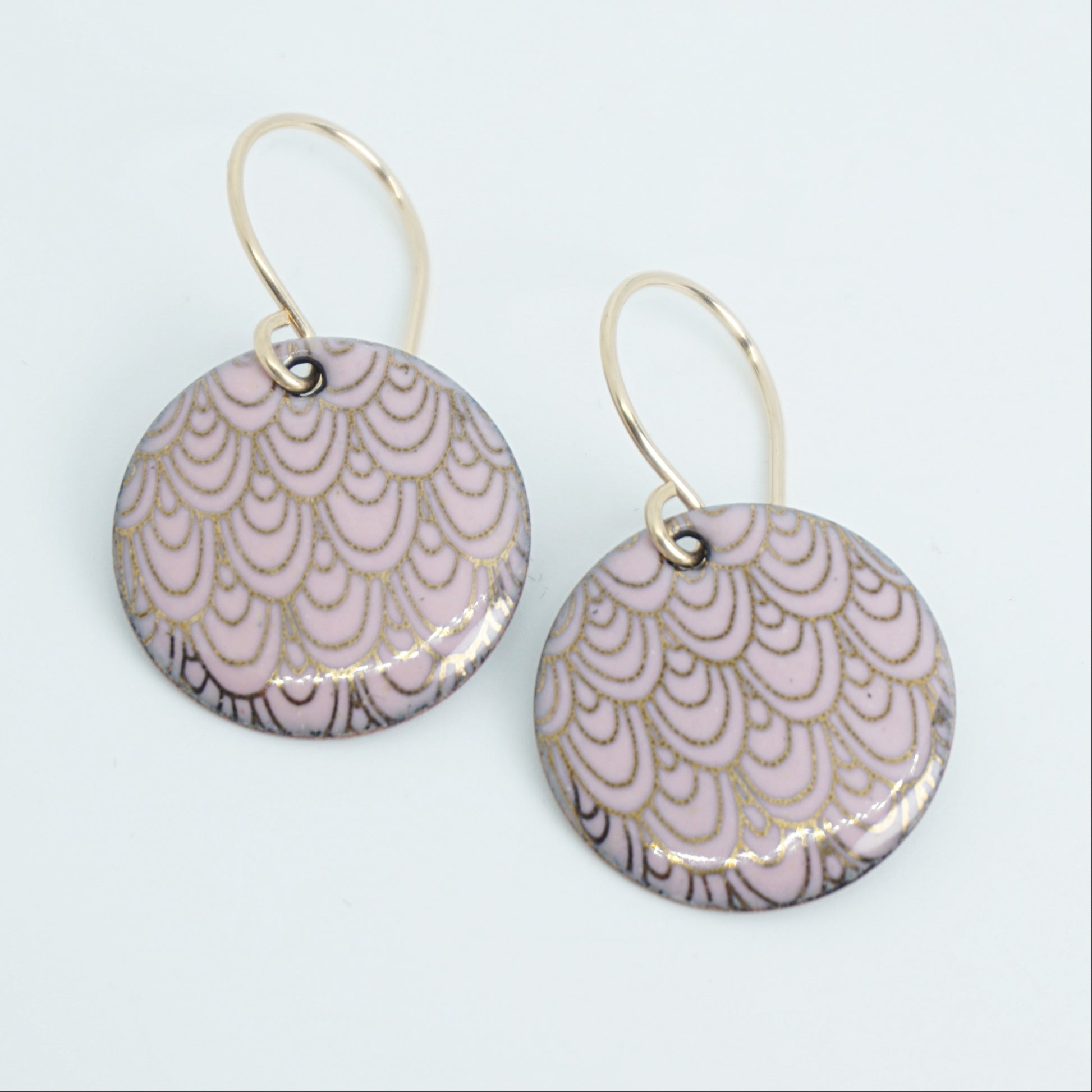 Pair of earrings with pink and gold pattern on a white background