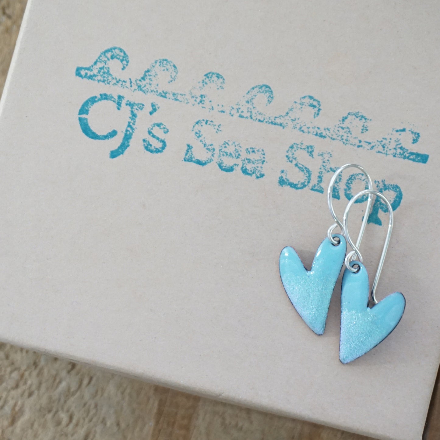Blue heart-shaped earrings on a gift box