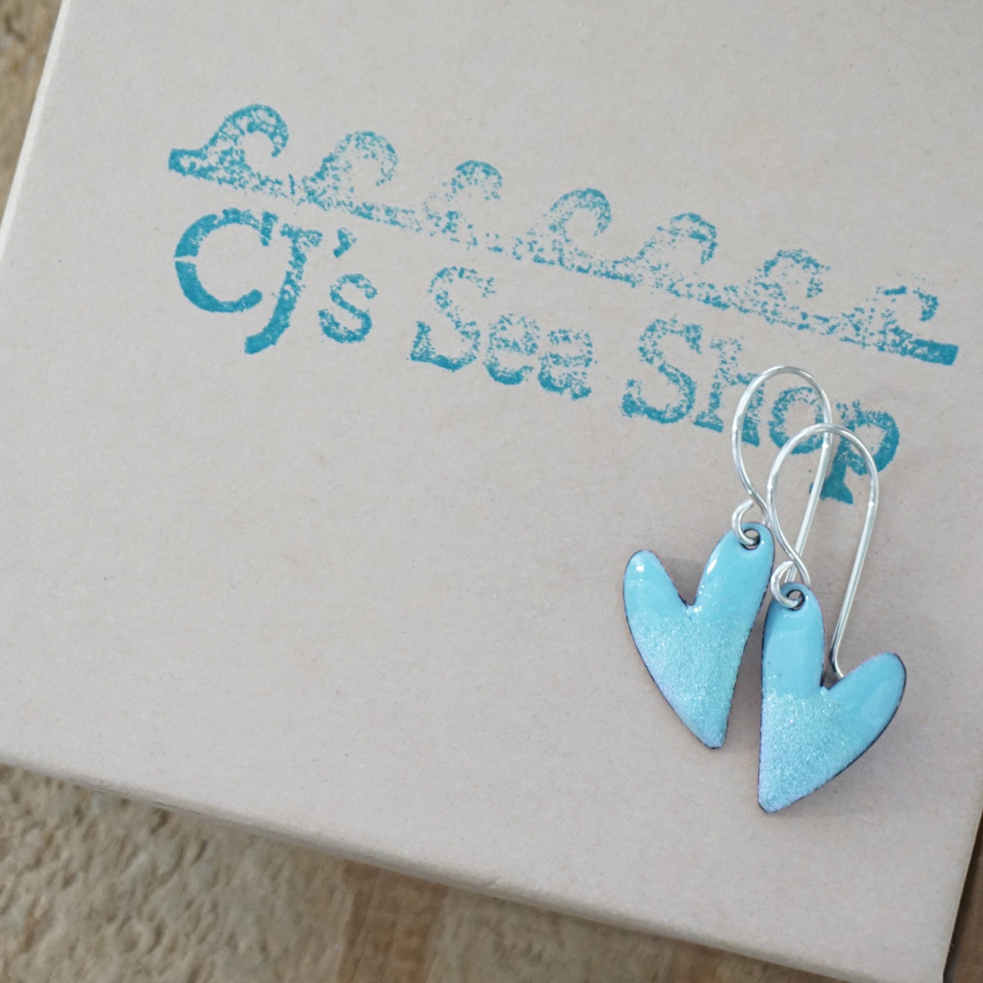 Blue heart-shaped earrings on a gift box