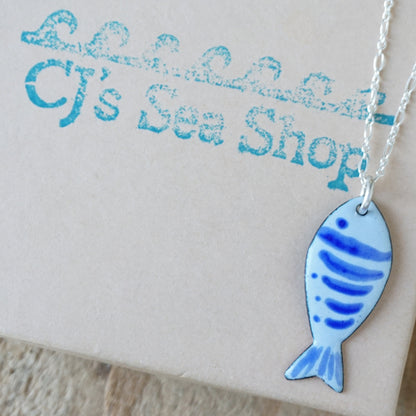 Blue fish-shaped pendant on a gift box