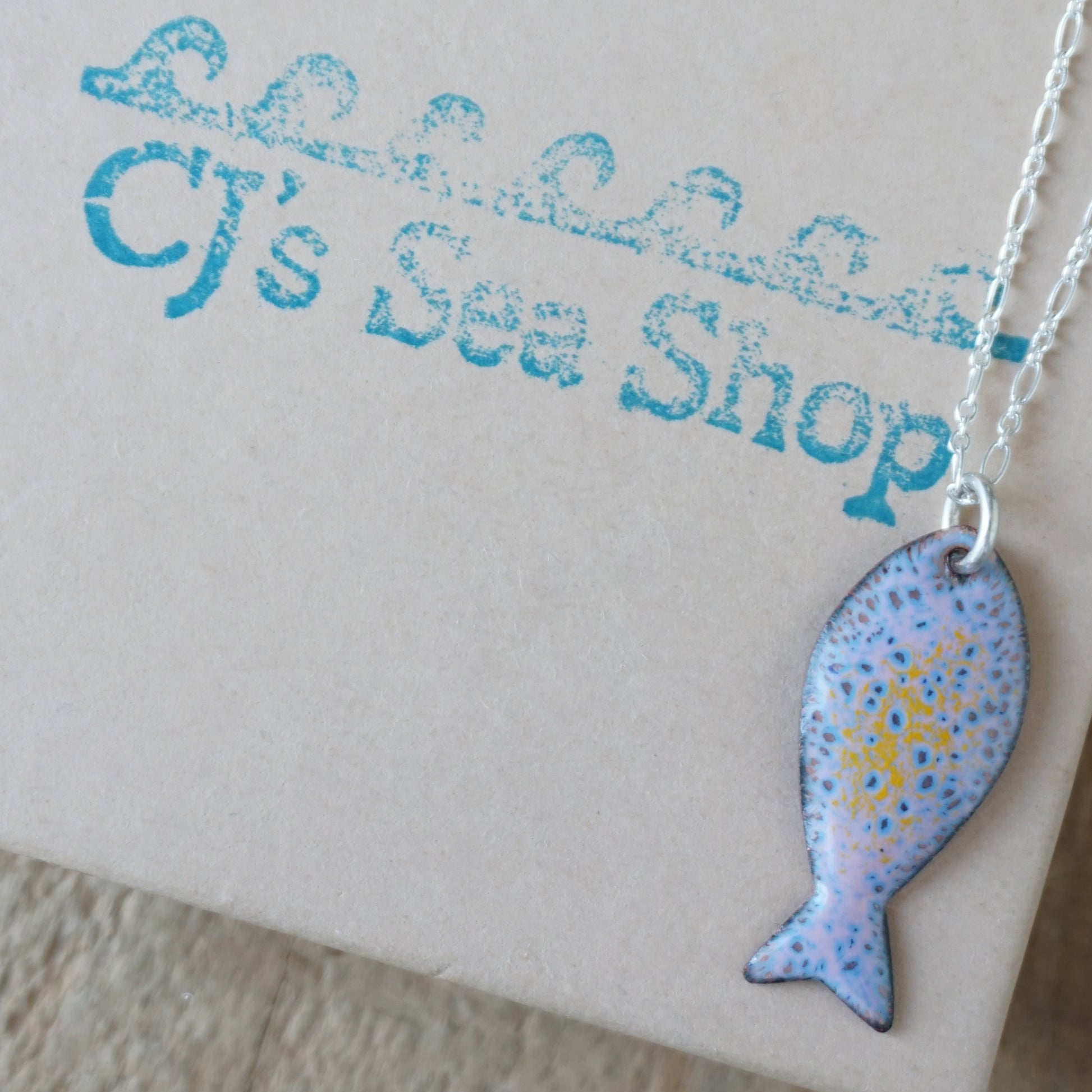 Fish-shaped pendant necklace on a gift box