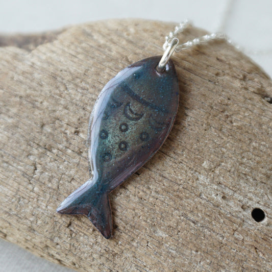 Fish-shaped pendant on a wooden surface