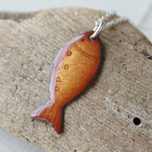 Fish-shaped pendant on a wooden surface