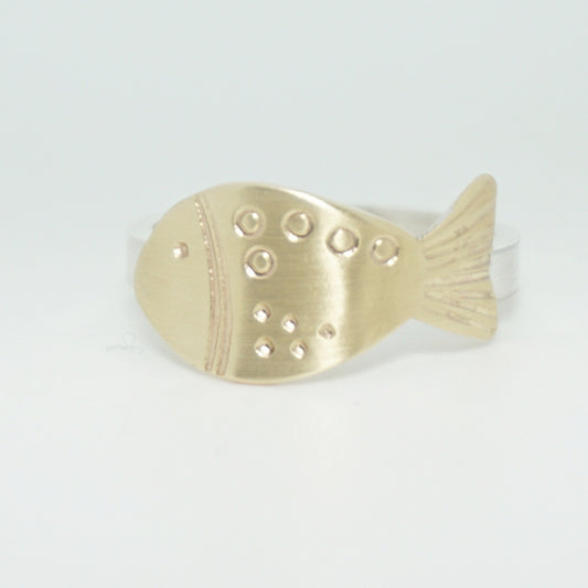 hand stamped brass fish on a silver band, against a white background