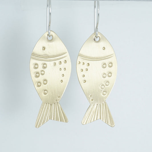 brass fish-shaped earrings on a white background