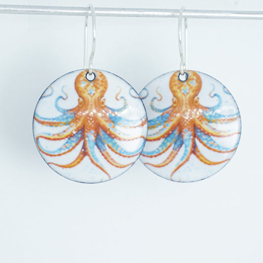 Pair of round earrings with octopus design on a white background