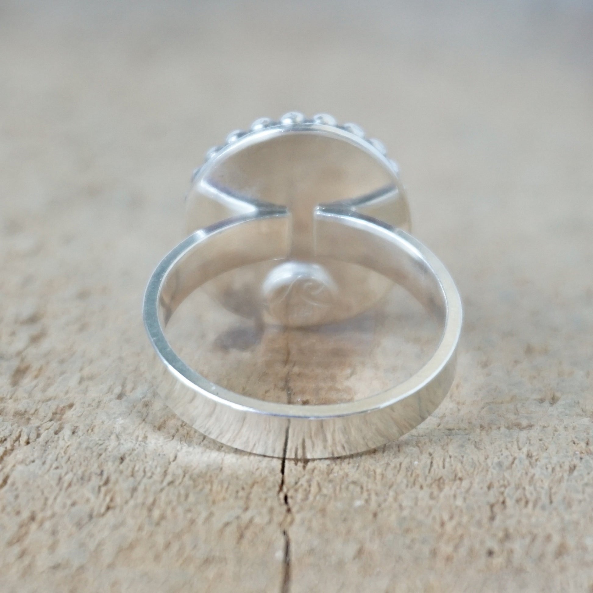 Silver ring with a turquoise stone on a wooden surface