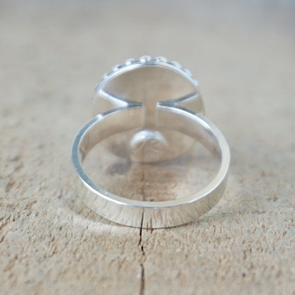 Silver ring with a turquoise stone on a wooden surface