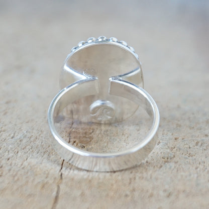 Silver ring with turquoise stone on a wooden surface