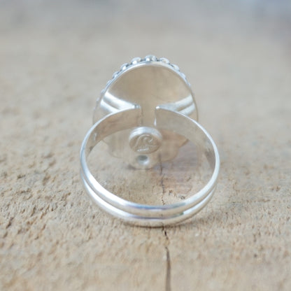 Silver ring with a turquoise stone on a wooden surface