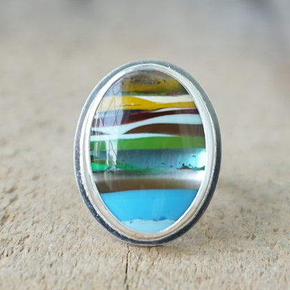 Multicolored striped ring on a wooden surface