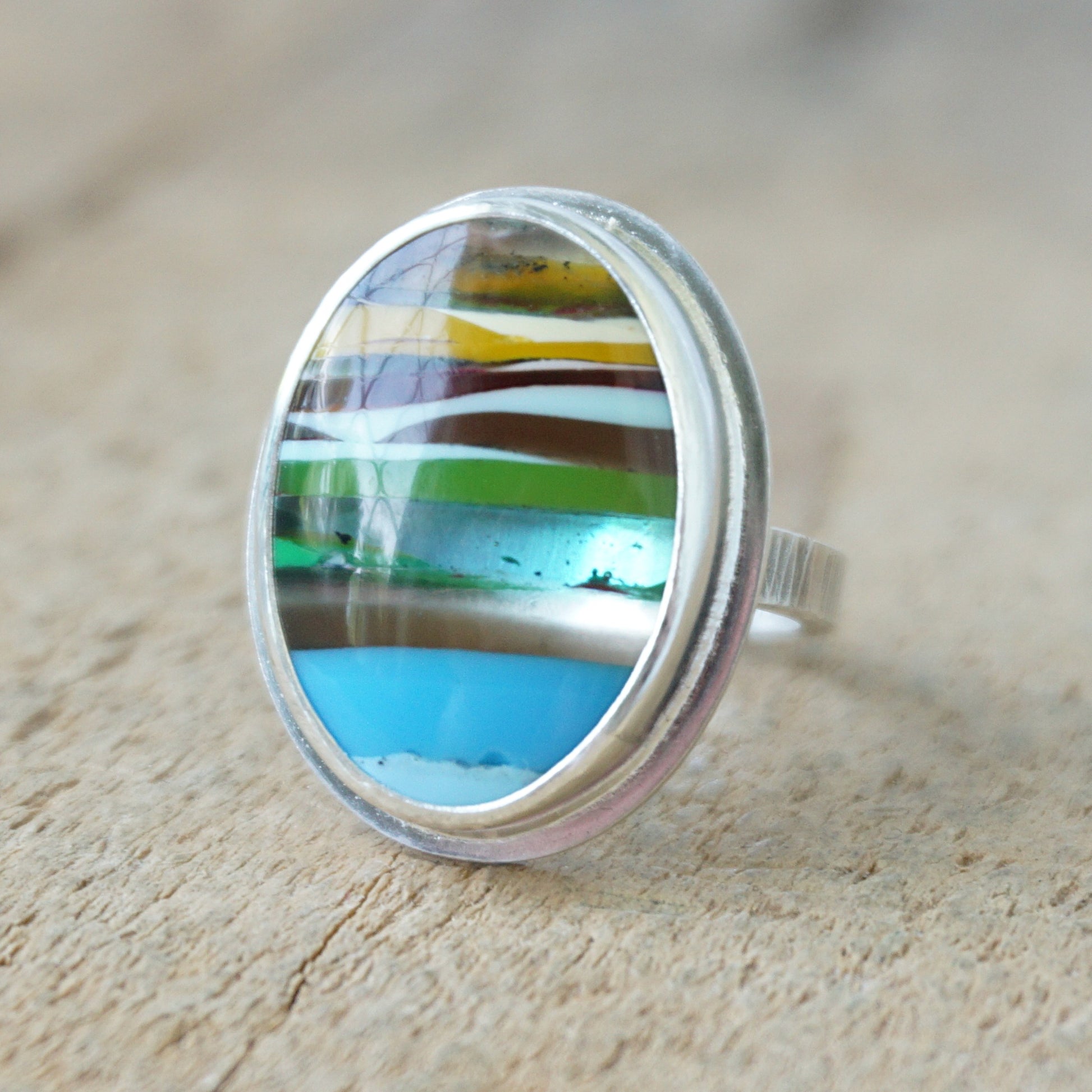 Ring with a colorful stone on a wooden surface