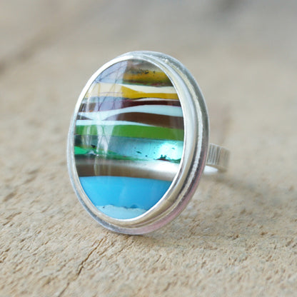 Ring with a colorful stone on a wooden surface