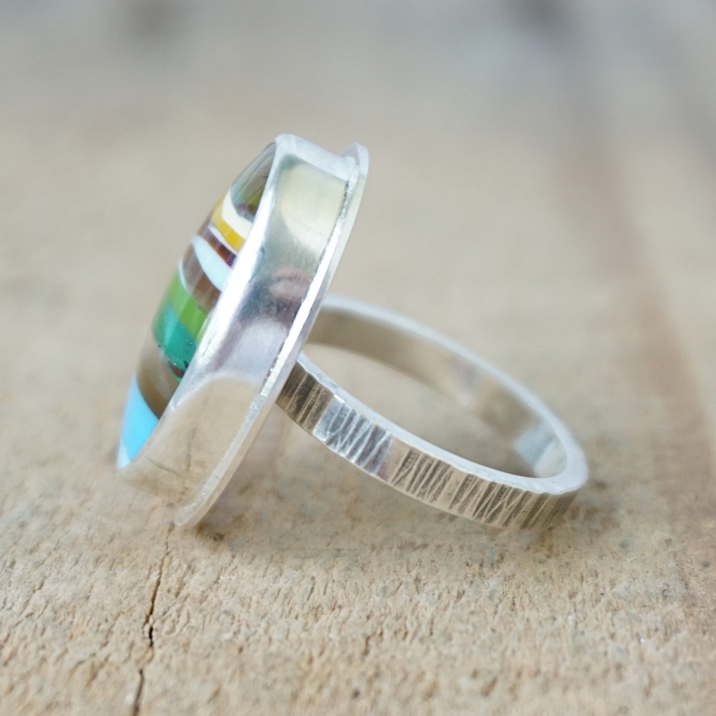 side view of a Multicolored striped ring on a wooden surface
