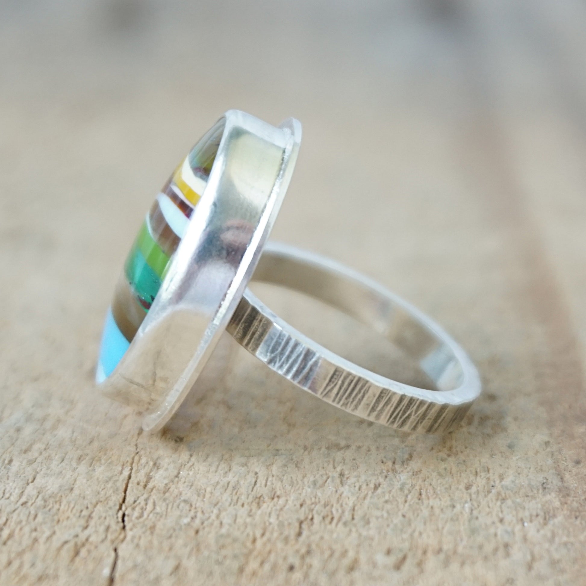 side view of a Multicolored striped ring on a wooden surface