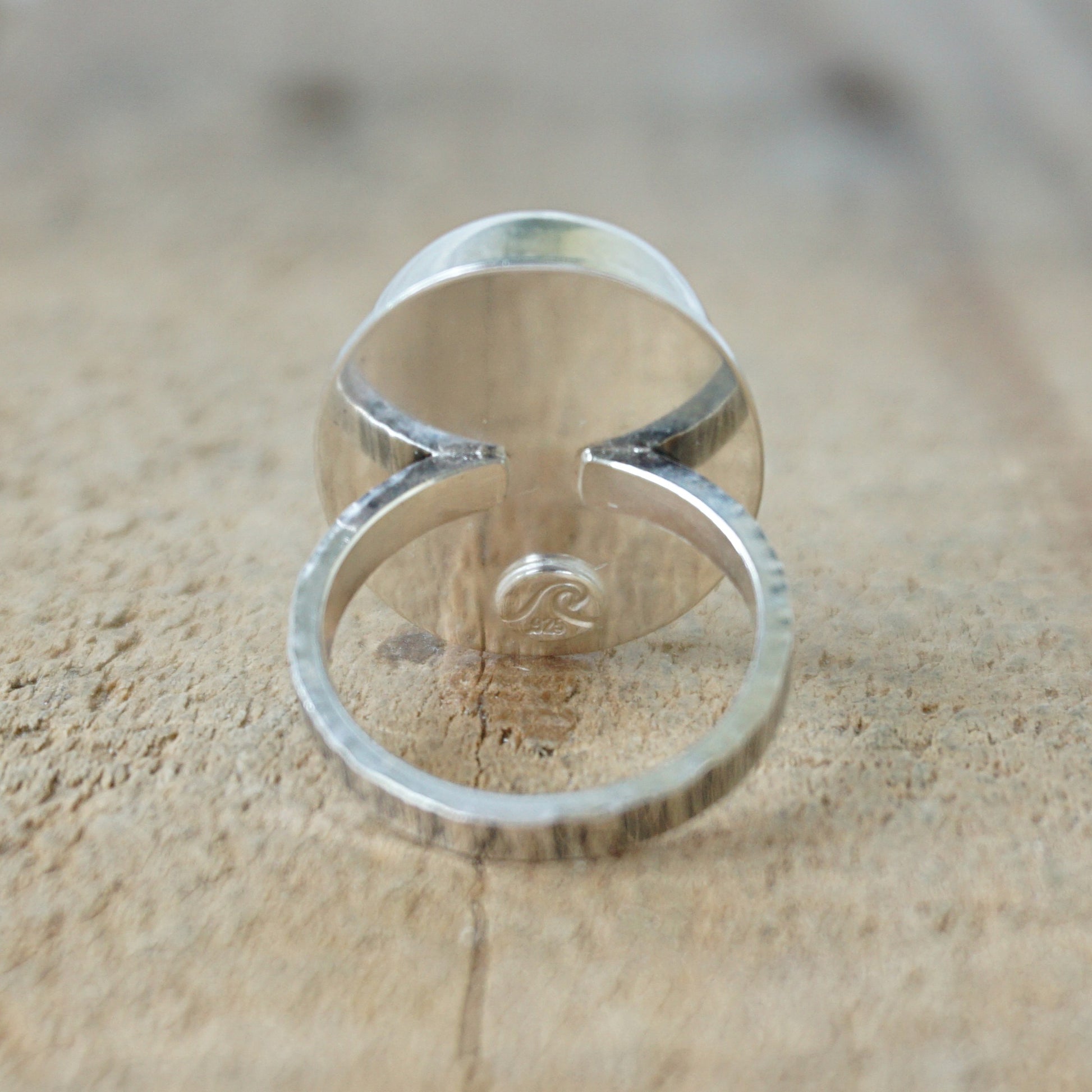 back view of a Multicolored striped ring on a wooden surface