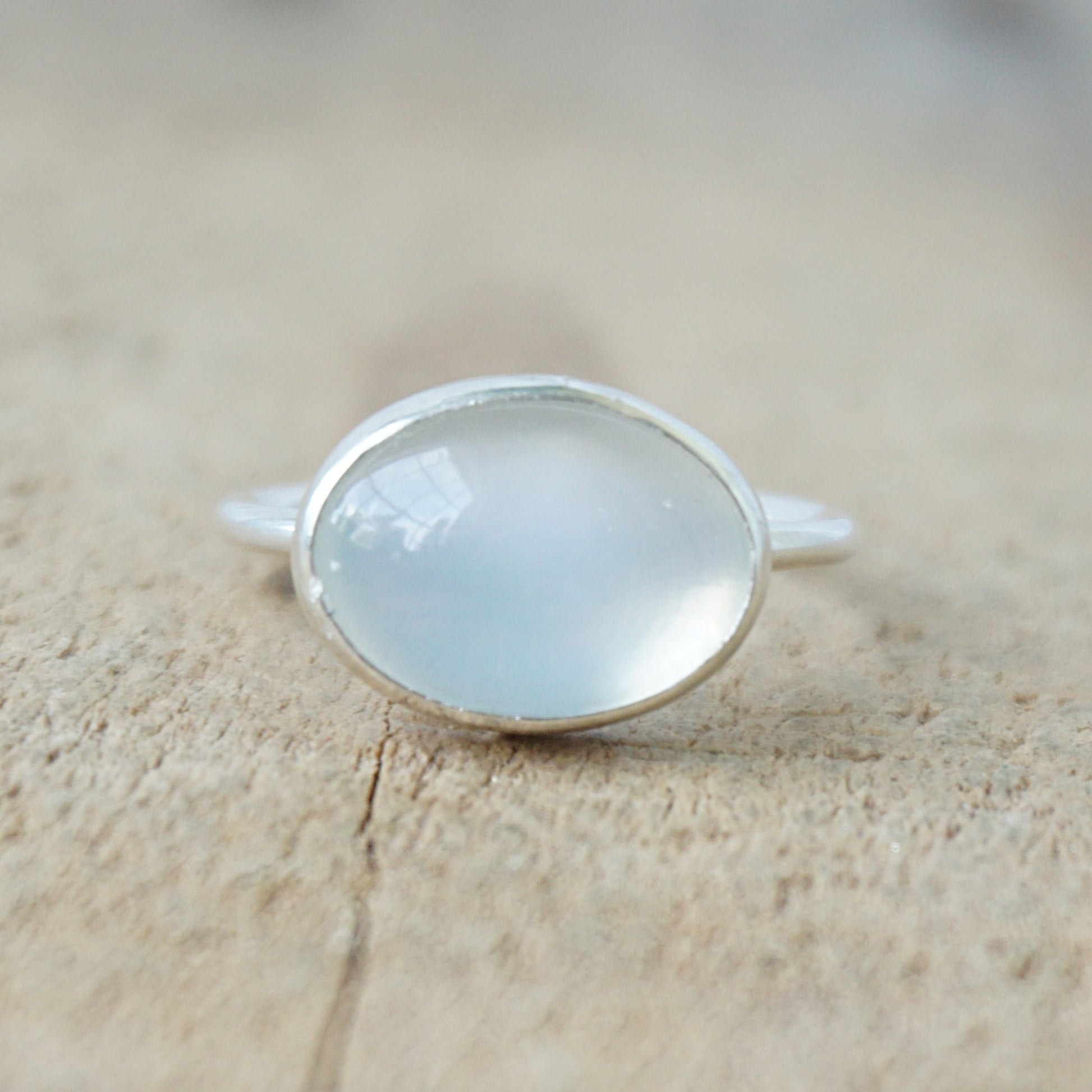 silver ring with a translucent stone on a wooden background